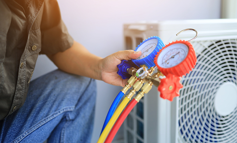 Image of HVAC technician repairing an outside HVAC unit - Lockey Heating and Air